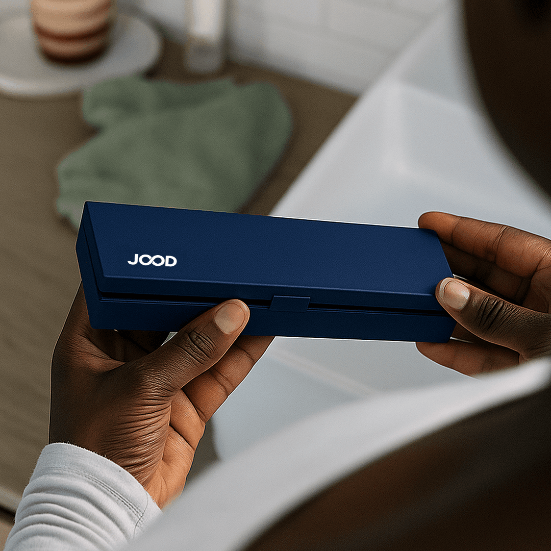 A hand holding the JoodLife device